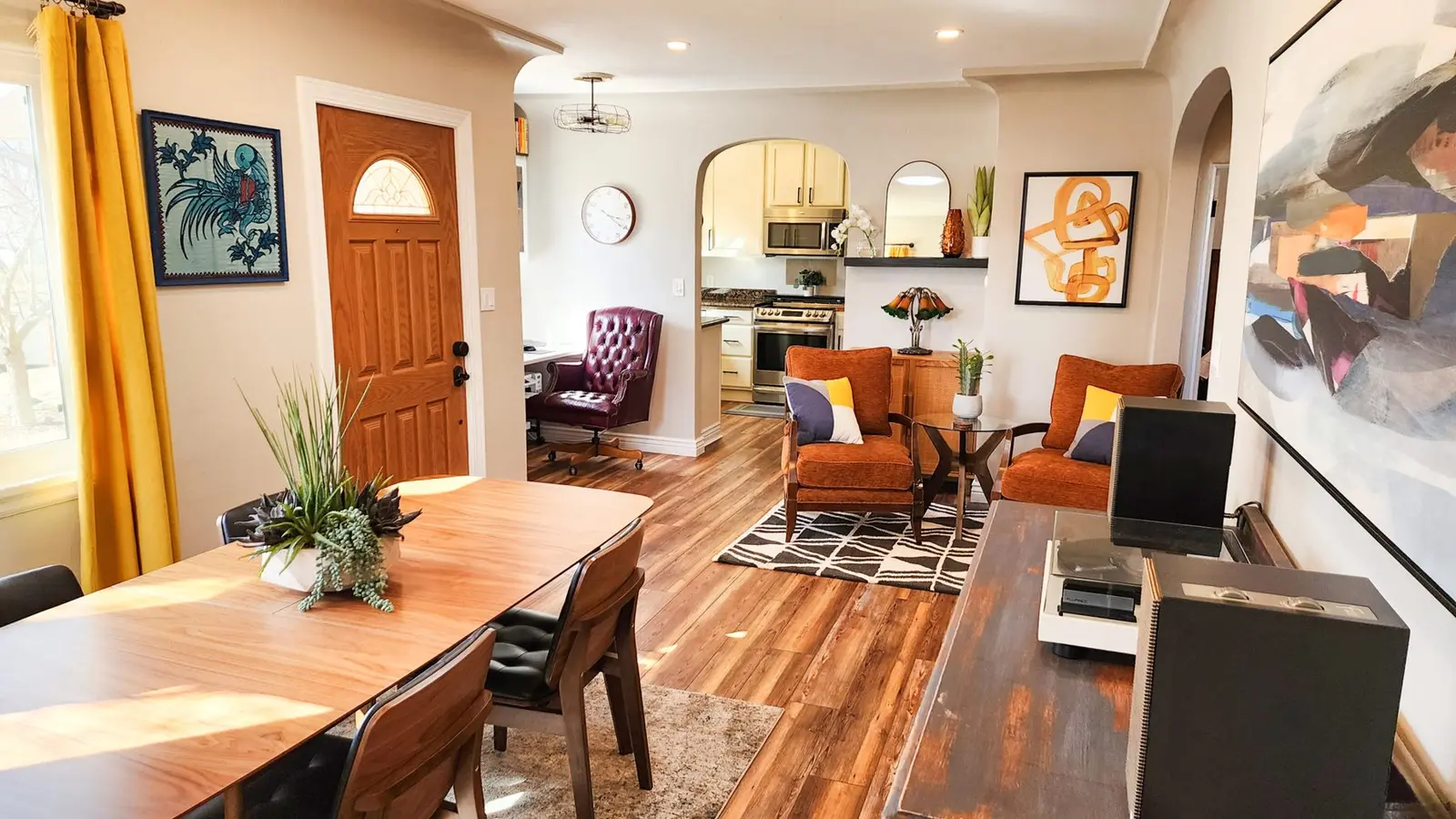 Open dining and living space at The Elati House with a long wood table and a record player