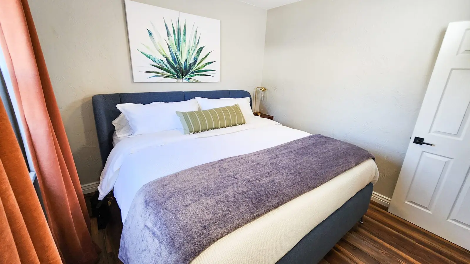 A bedroom at The Elati House with a king bed and an agave print above it