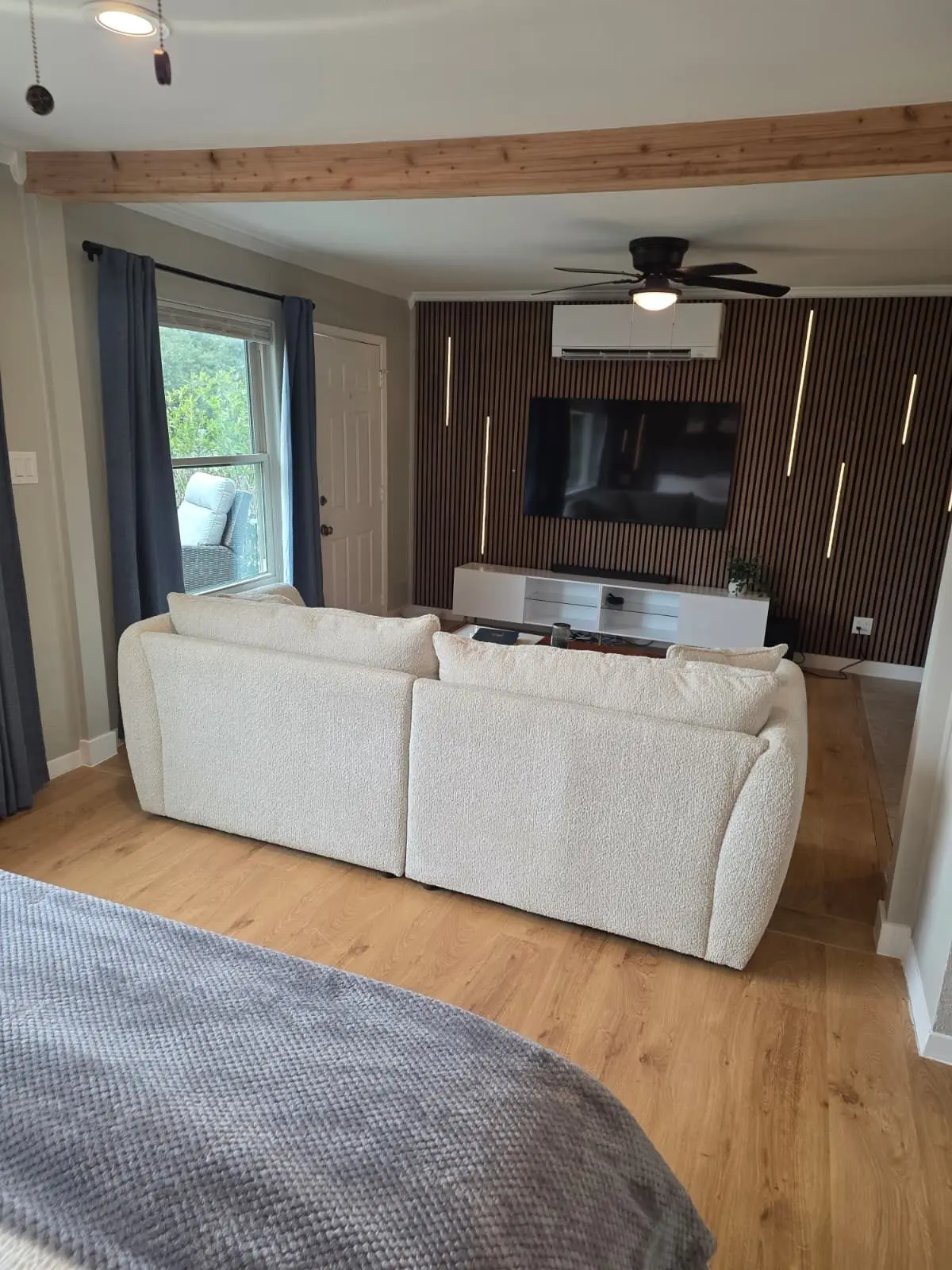 The McCosh Apartment living area with a white sofa and a wood-slat accent wall