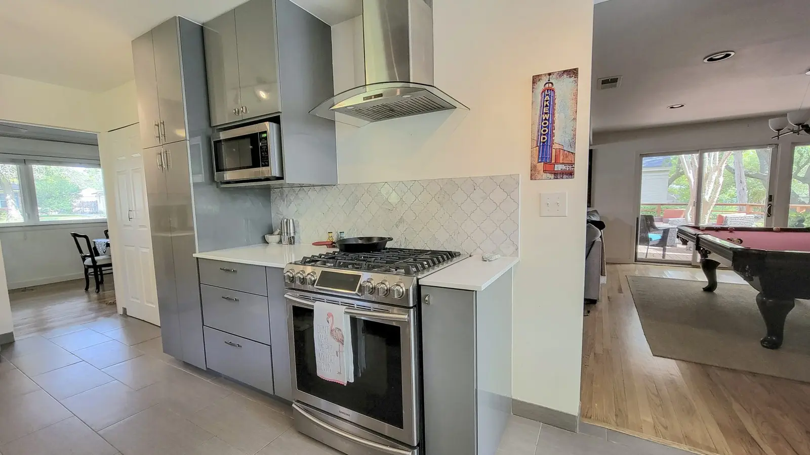 The McCosh House kitchen with a gas range, range hood and gray cabinets
